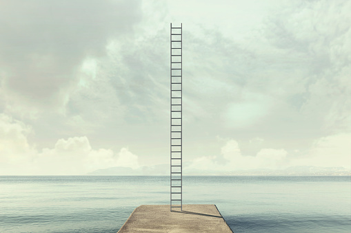 surreal ladder rises up into the sky in a silent sea landscape