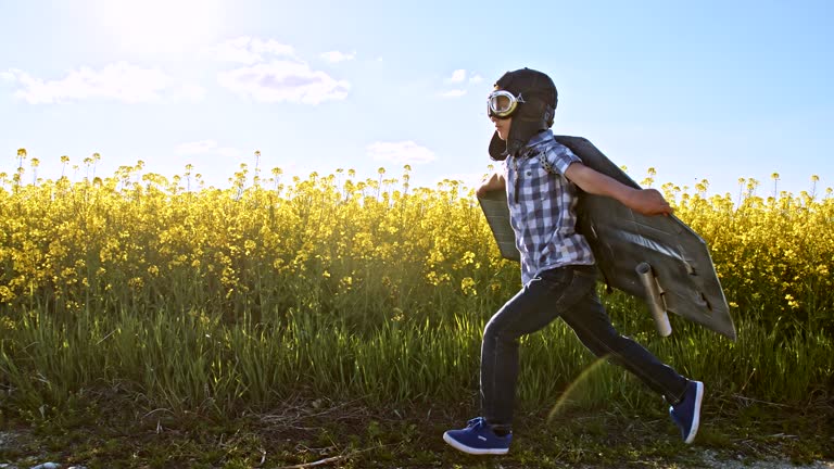 SLO MO Funny little boy running on a dirt road in a jet pack costume