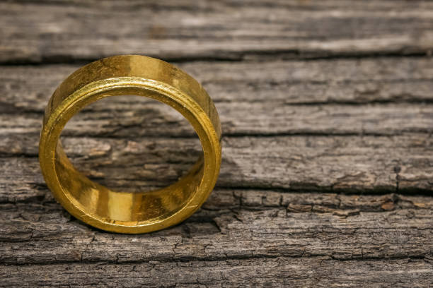 One single simple golden ring on the wooden table with copy space