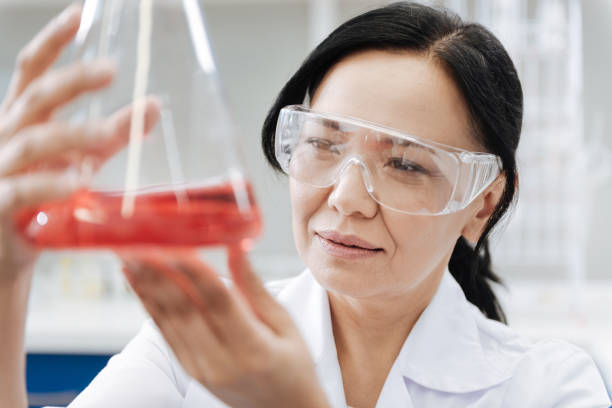 istock Serious intelligent woman looking at the flask 825250818