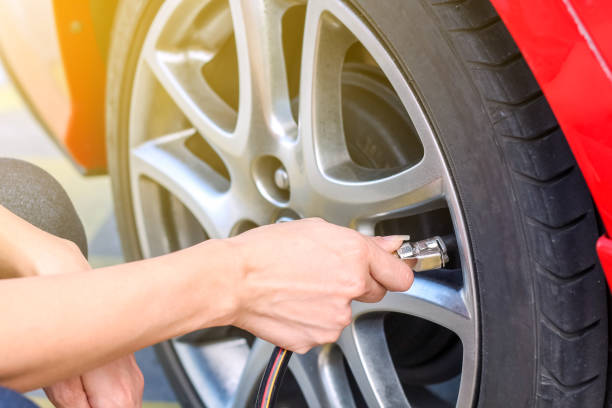 Woman Filling air into a car tire to increase pressure Woman Filling air into a car tire to increase pressure inflating photos stock pictures, royalty-free photos & images