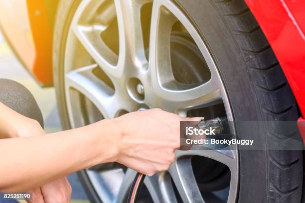 Woman Filling Air Into A Car Tire To Increase Pressure Stock Photo - Download Image Now