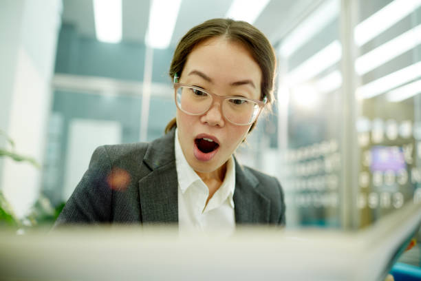 istock Shocked Businesswoman reading Newspaper 825254752