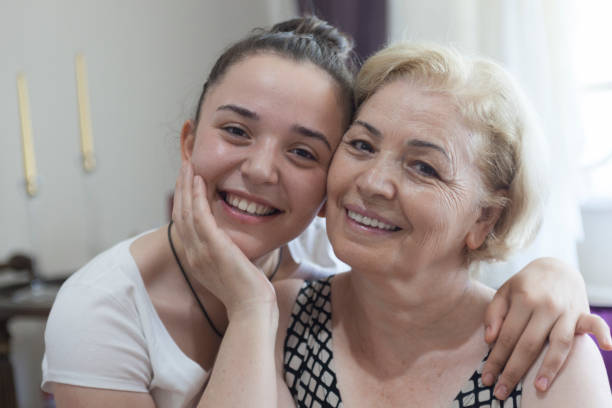 Smiling mother and young daughter posing to camera