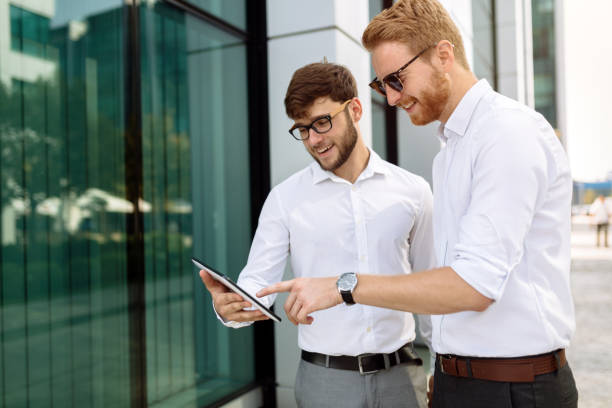 istock Businesspeople looking at tablet outdoors 825266942