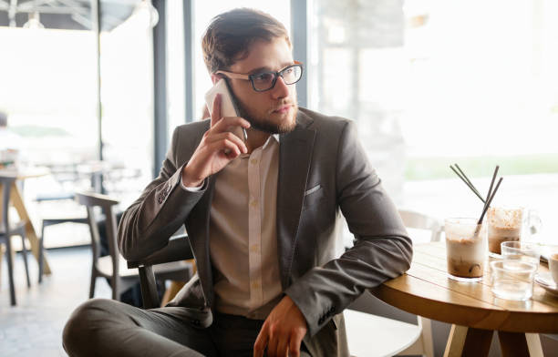 istock Businessman wearing glasses talking on phone in cafe 825267218