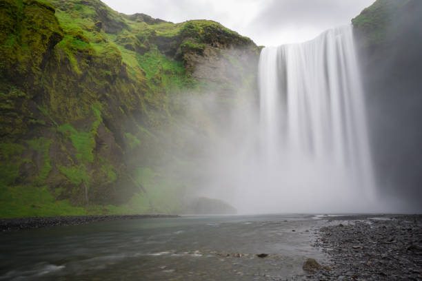 istock Iceland - Skogafoss waterfall and river with green steep face 825267712