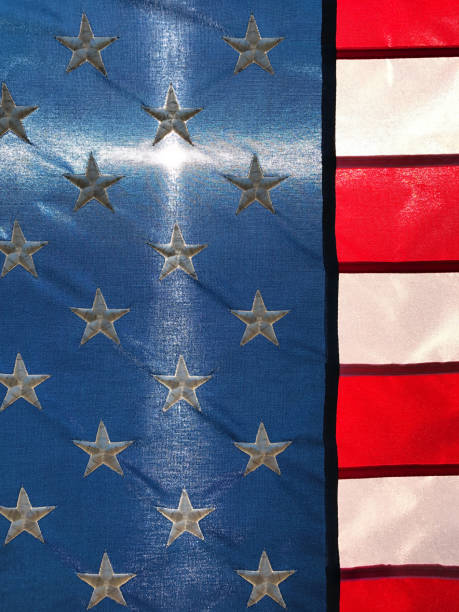 istock Christian cross forms as sunlight passes through American Flag 825270512