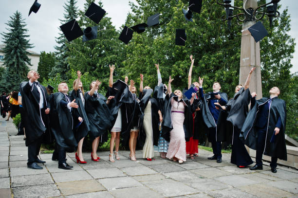 istock Happy university graduates throwing their graduation caps into the air. 825279244
