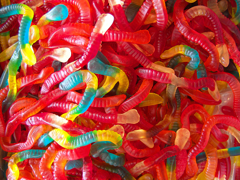 Gummy colorful worms, food background