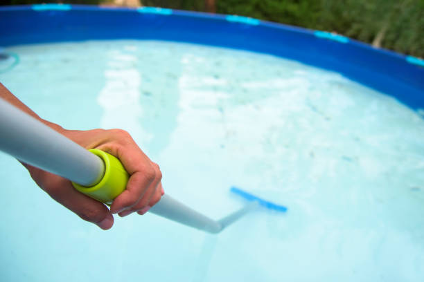 istock young man cleaning a portable swimming pool 825288196