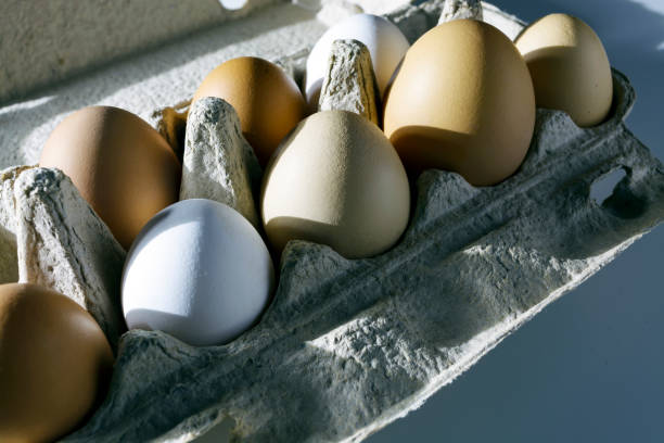 istock Rustic eggs in the package by the rays morning sun. Ready to Breakfast 825291994