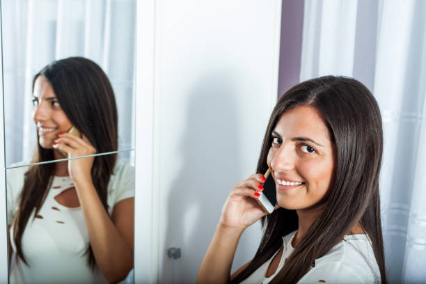 istock The girl looks in the camera while she is calling by the mirror 825295270