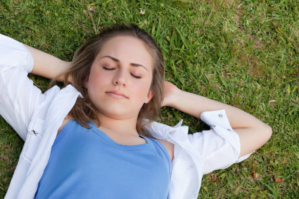 istock Young relaxed girl sleeeping on the grass 825313558