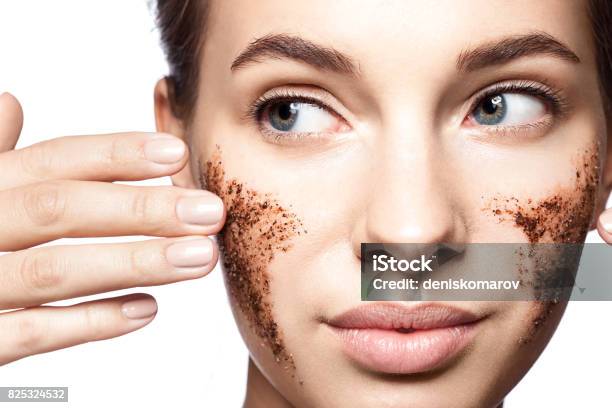 Closeup Portrait Of A Beautiful Woman With A Coffee Scrub On Her Face Doing Peeling Skin Isolated On White Background Stock Photo - Download Image Now