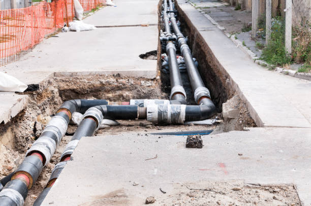 istock District heating pipeline reparation and reconstruction parallel with the street with construction site safety net fence. Selective focus. 825324792