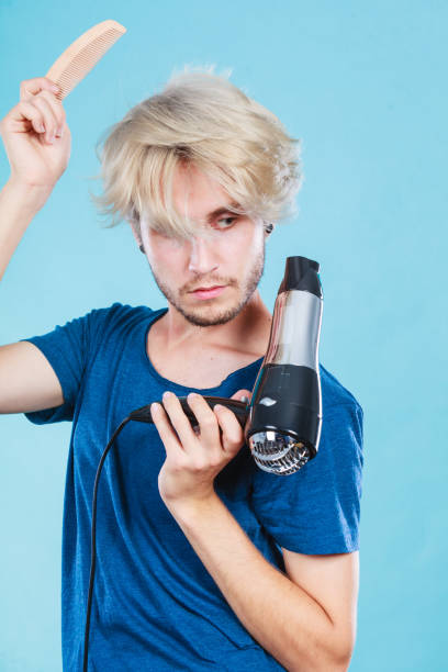 istock Trendy man with hair dryer 825325910