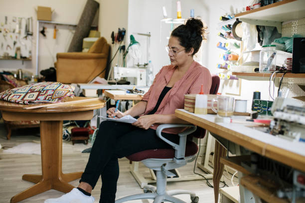 istock Small Business Owner Sitting In Studio Doing Paperwork 825336186