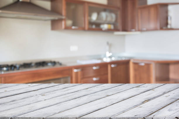istock Blurred and abstract kitchen background. Empty wooden tabletop and defocused modern kitchen for display or montage your products. 825336202