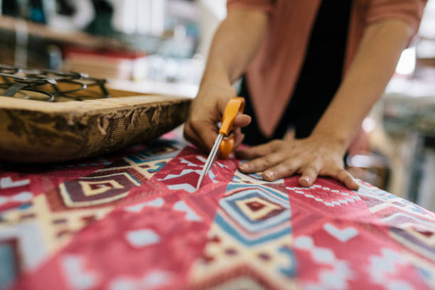 Close-up Craftswoman Cutting Colorful Fabric To Size stock photo