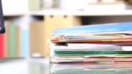 istock Stack of files, documents being piled onto office desk. 825340524