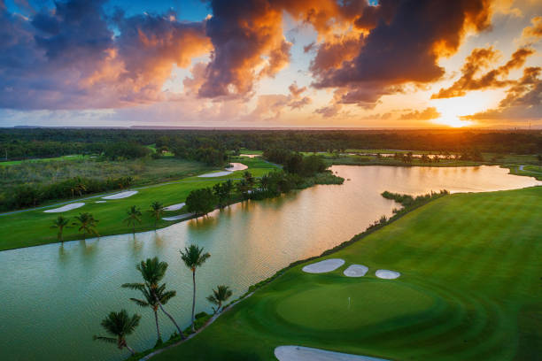 вид с воздуха на тропическое поле для гольфа на закате, доминиканская республика, пунта-кану - golf golf flag sunset flag стоковые фото и изображения