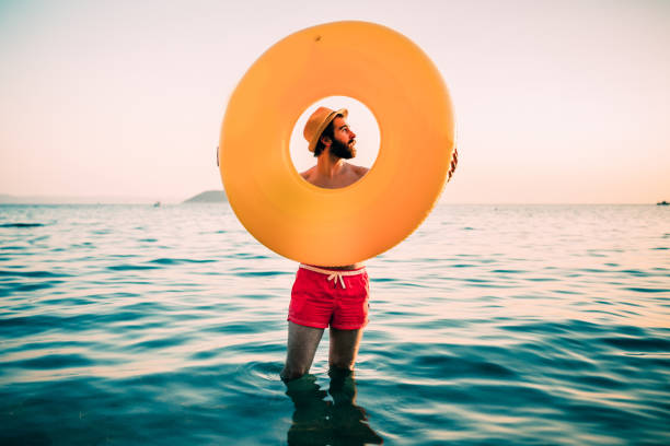 istock Handsome bearded man enjoying sunny summer day at the beach 825349472