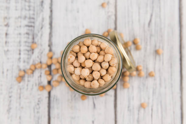istock Portion of dried Chickpeas on wooden background, selective focus 825352002