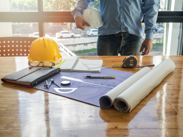 istock Blueprint on wooden desk with architect background, vintage tone 825356304