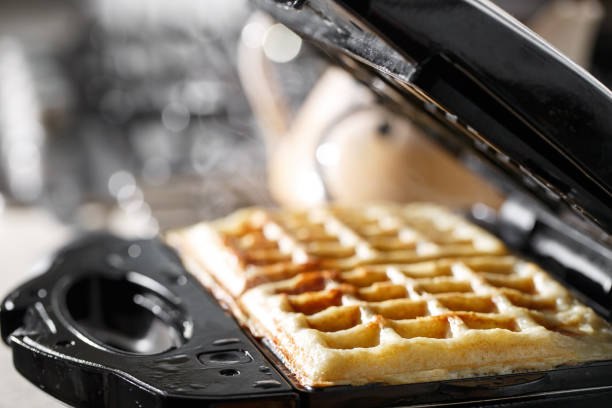 istock Freshly baked traditional Belgian waffles in iron waffle maker 825356780