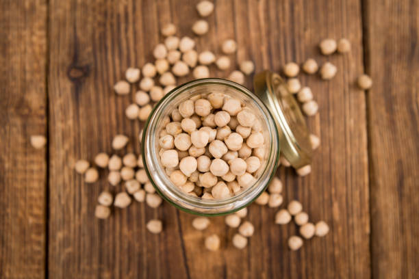 istock Portion of dried Chickpeas on wooden background, selective focus 825359488