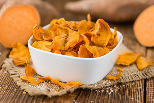 Sweet Potato Chips on a vintage background as detailed close-up shot, selective focus