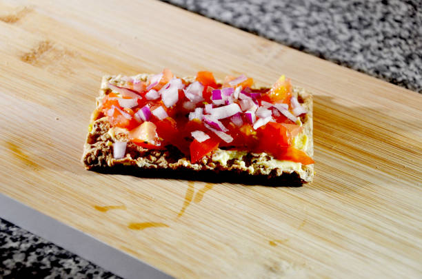 Ryvita Crackers with tomatoe and onions tasty cracker with tomatoes and red onions Ryvita stock pictures, royalty-free photos & images
