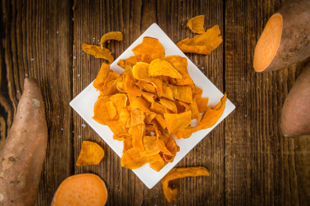 istock Sweet Potato Chips on wooden background; selective focus 825371426