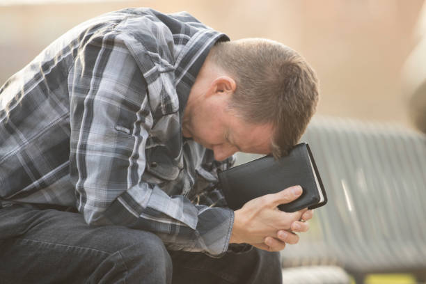 Man sitting on bench with Bible