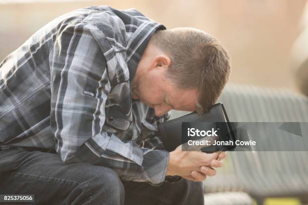 Man Sitting On Bench With Bible Stock Photo - Download Image Now - Praying, Men, Bible