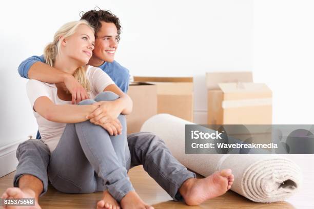 Smiling Couple Sitting On The Floor Stock Photo - Download Image Now - 20-24 Years, 20-29 Years, Adult