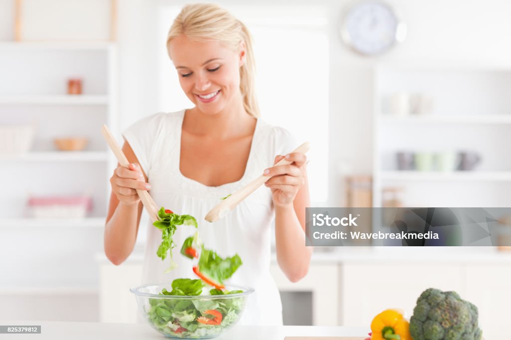 Gorgeous woman mixing a salad Gorgeous woman mixing a salad in her kitchen 20-24 Years Stock Photo