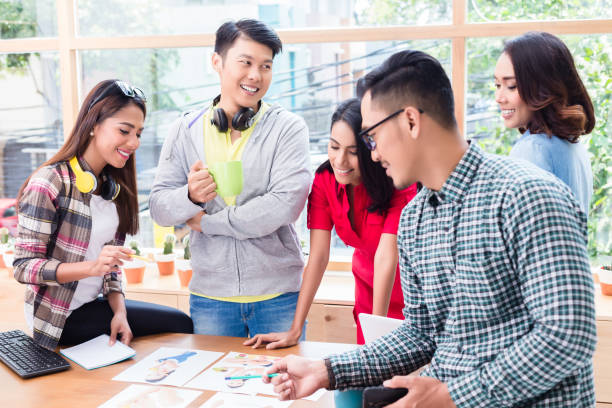 istock Young team analyzing business information during brainstorming meeting 825382026