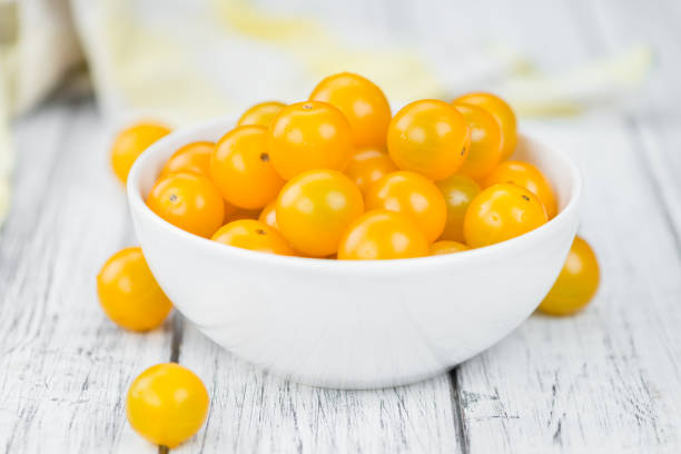 istock Wooden table with Yellow Tomatoes, selective focus 825382090