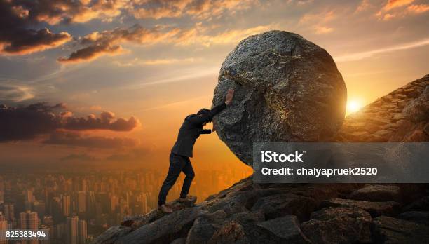 Business Man Pushing Large Stone Up To Hill Business Heavy Tasks And Problems Concept Stock Photo - Download Image Now