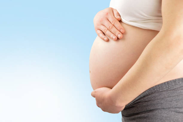 istock woman holding her pregnant belly 825387334