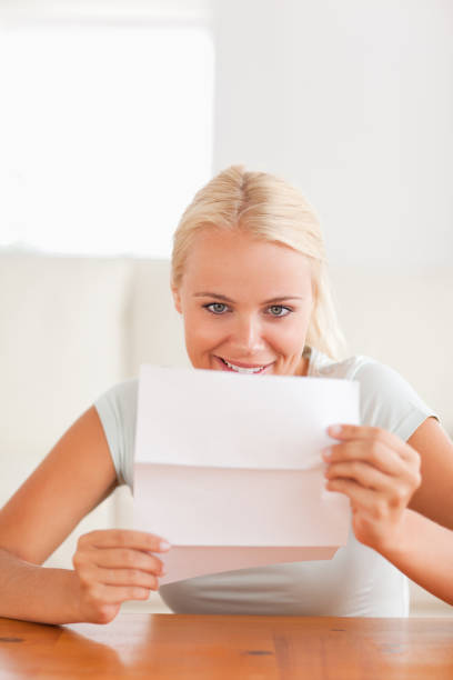 istock Smiling woman reading a letter 825390110