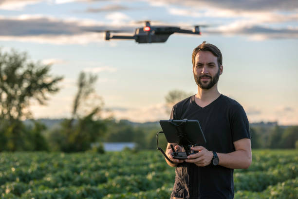 piloto de homem usando o controlador remoto drone ao pôr do sol - controlado à distância - fotografias e filmes do acervo