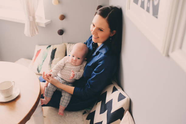 istock happy young mother having breakfast in kitchen with her baby daughter 825394772