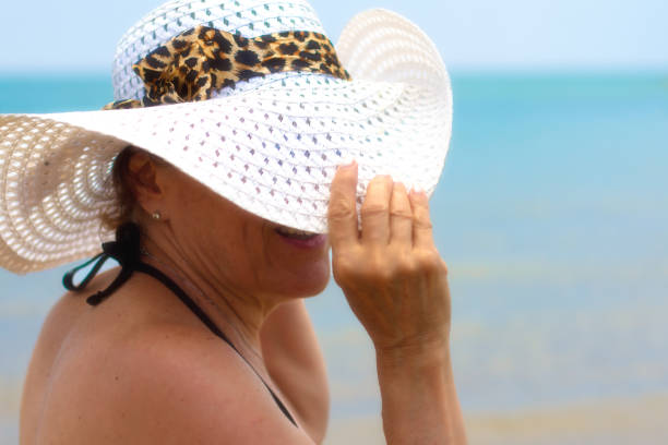 istock Woman in White Sunhat at Water's Edge 825404974