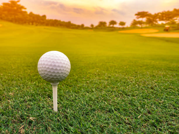 zbliżenie profesjonalnej piłki golfowej na trójce, gotowe do tee off shot, tło wschodu słońca - teeing off zdjęcia i obrazy z banku zdjęć