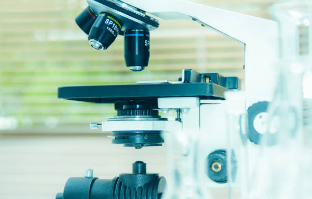 istock Close up the microscope with test sample making research in laboratory chemical formula for science concept, science background and selective focus. 825410248