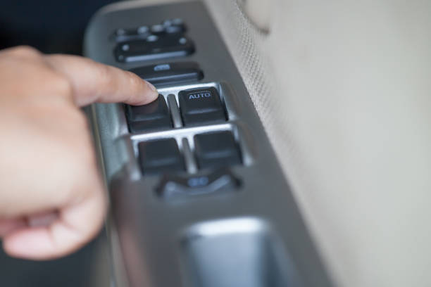 Woman hand pressing button controlling window in the car Woman hand pressing button controlling window in the car car door panels stock pictures, royalty-free photos & images