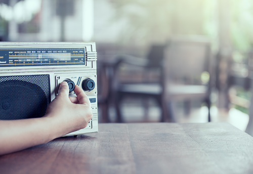Mano de mujer, ajuste el volumen del sonido en estéreo de cassette radio retro photo